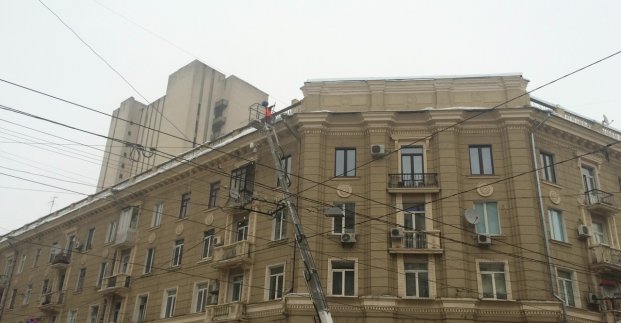В центре Харькова альпинисты убирают ледяные глыбы с крыш домов
