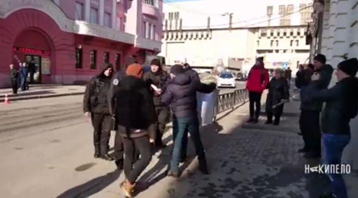 В Харькове у активиста люди с шевронами полиции пытались забрать плакат “Хто замовив Катю Гандзюк?” (видео)