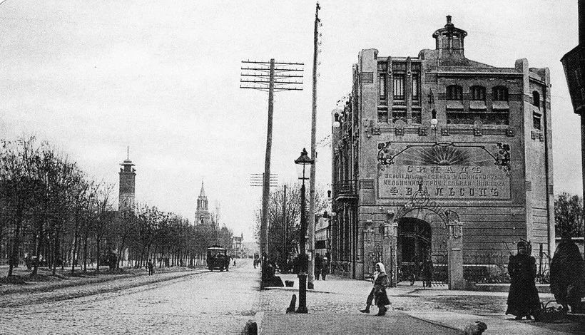 Ліворуч пожежна каланча, за нею шпиль церкви, посеред вулиці вагон. Де це?